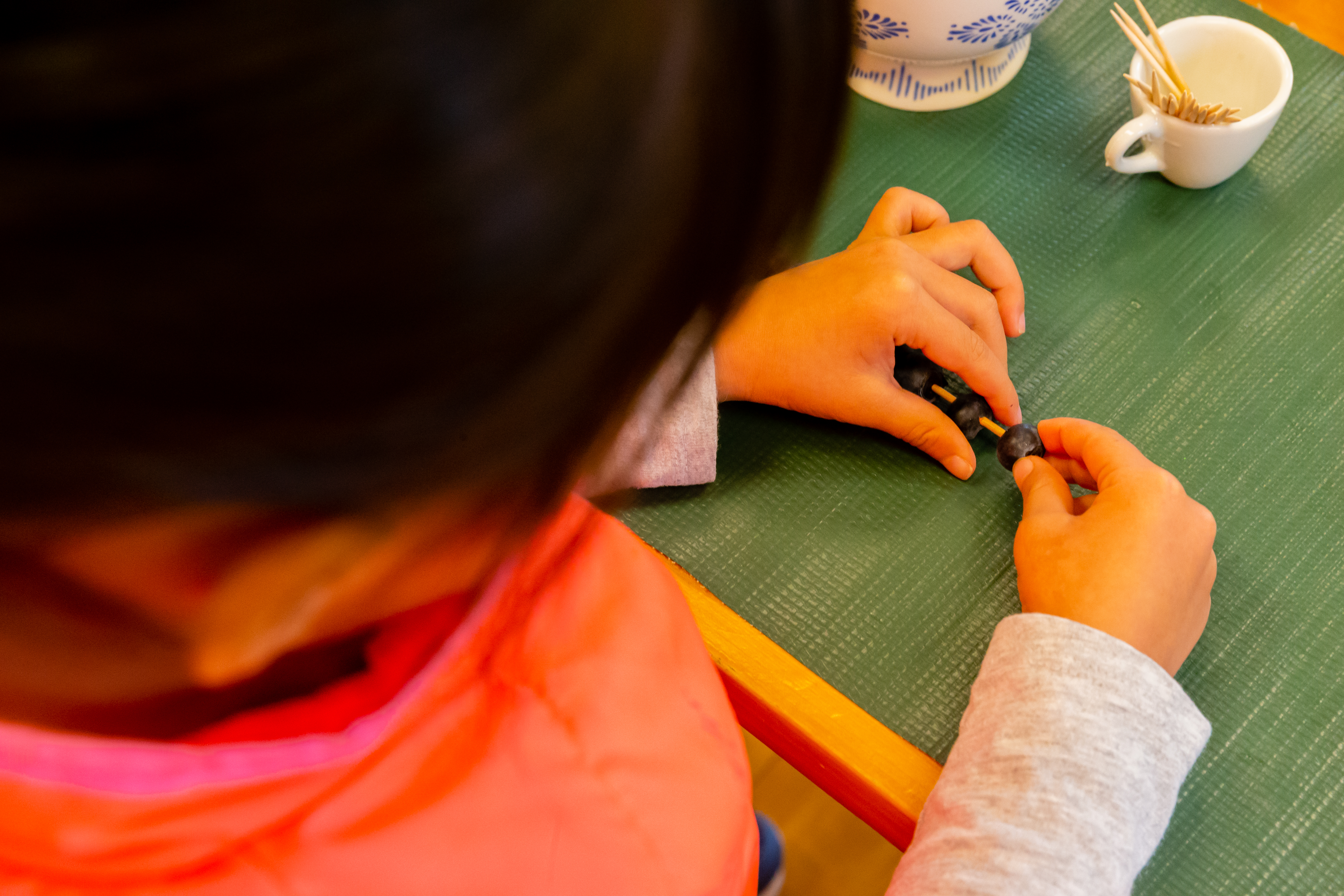 Girl placing blueberries in toothpick