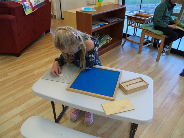 Montessori Elementary girl learning complex problems in an easy way