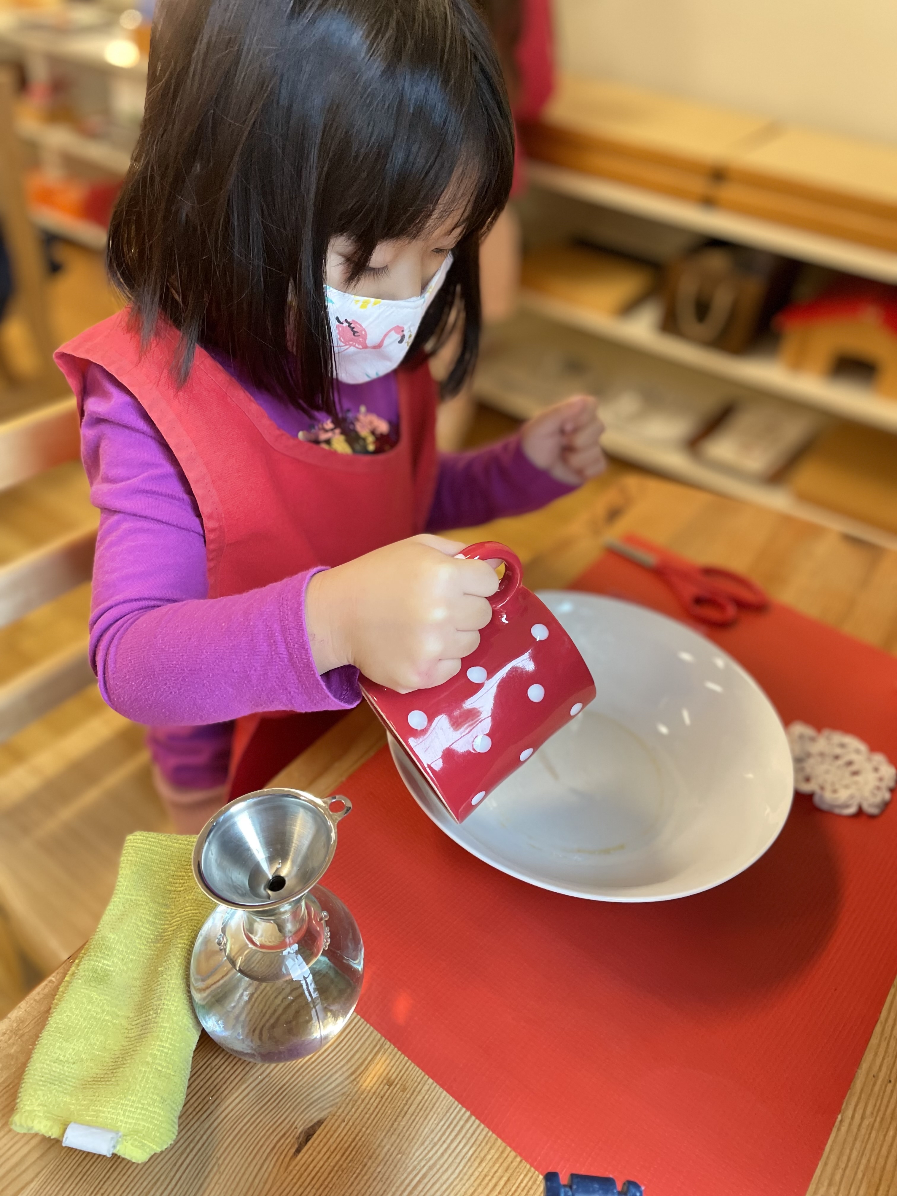 Child cutting fruit independently at Lifetime Montessori school in Santaluz