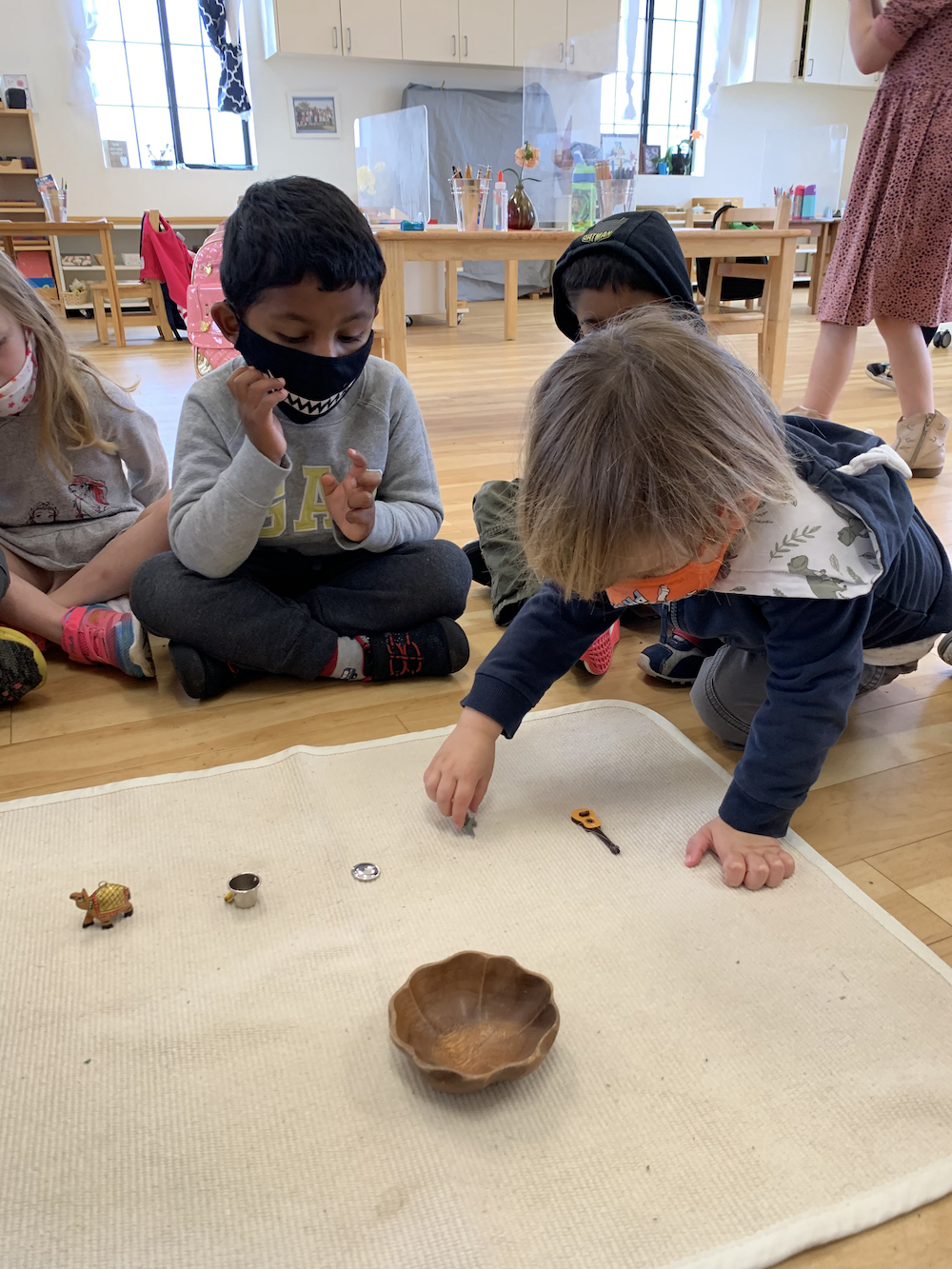 Toddlers in a Montessori classroom playing with small objects