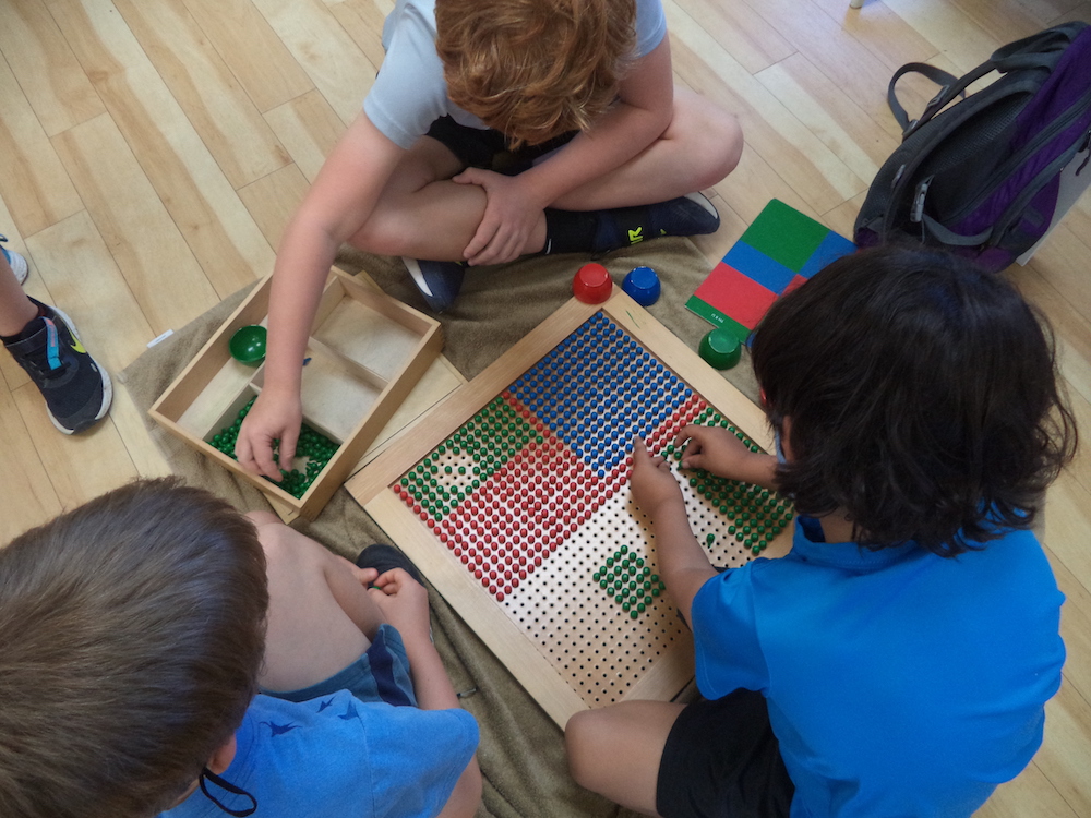 Elementary children solving math problems in a Montessori classroom