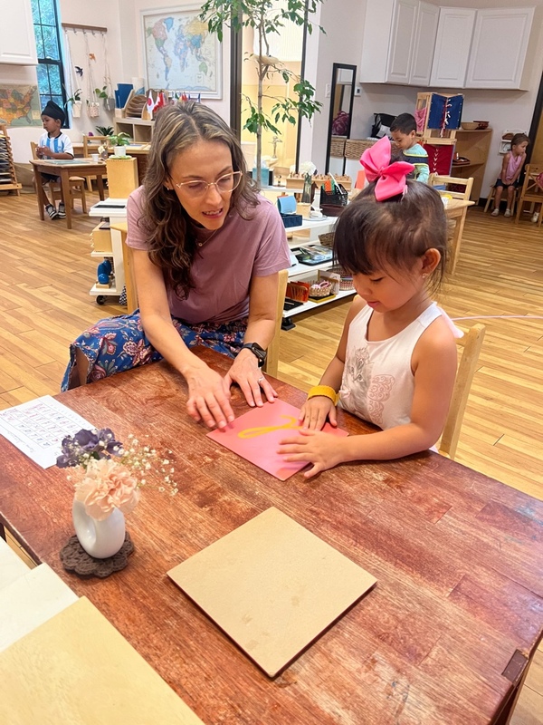 Montessori and Transitional Kindergarten (MTK) Montessori guide and Transitional Kindergarten child working together