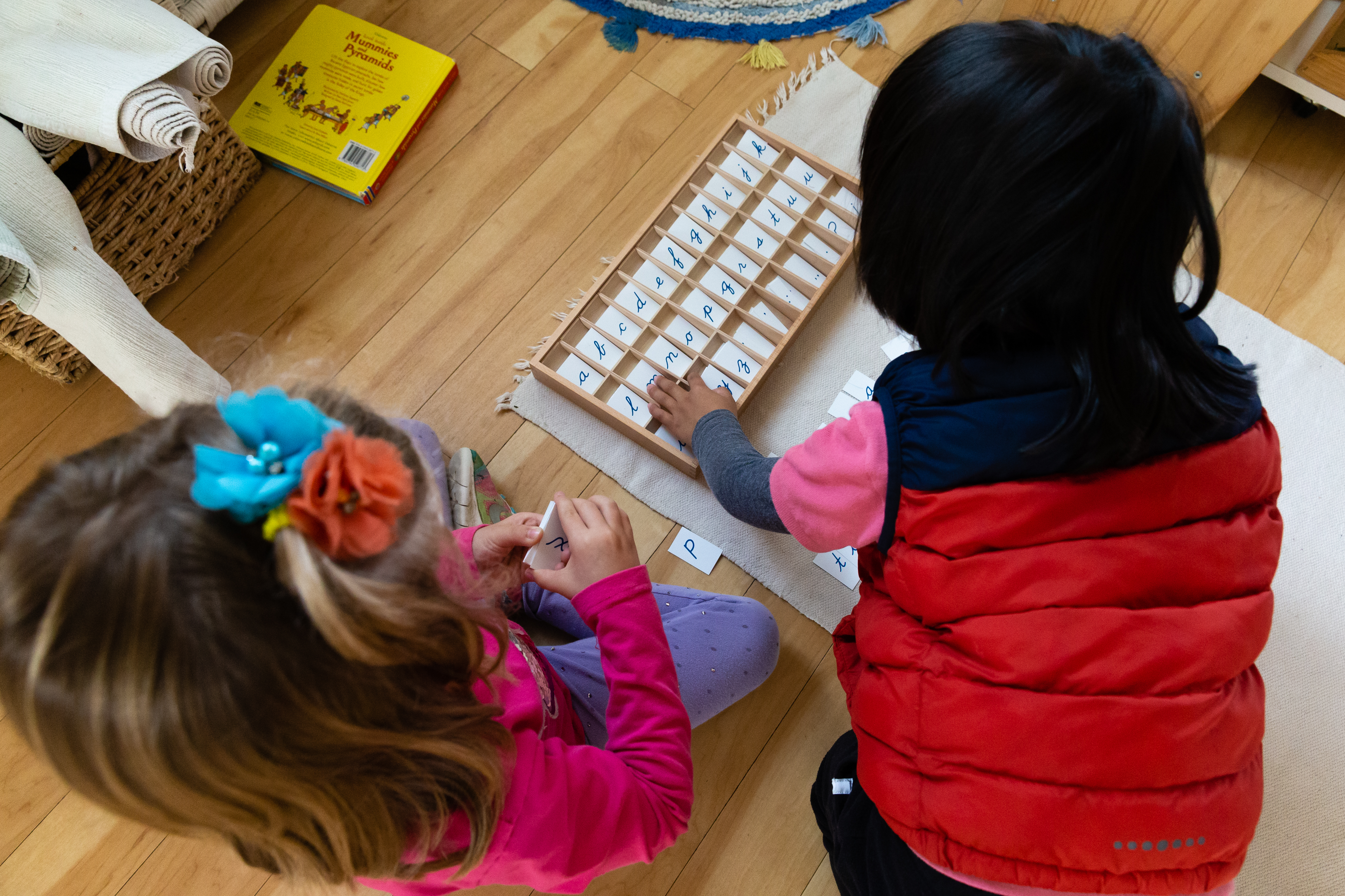 Boy and girl socializing while learning to spell in their Montessori classroom