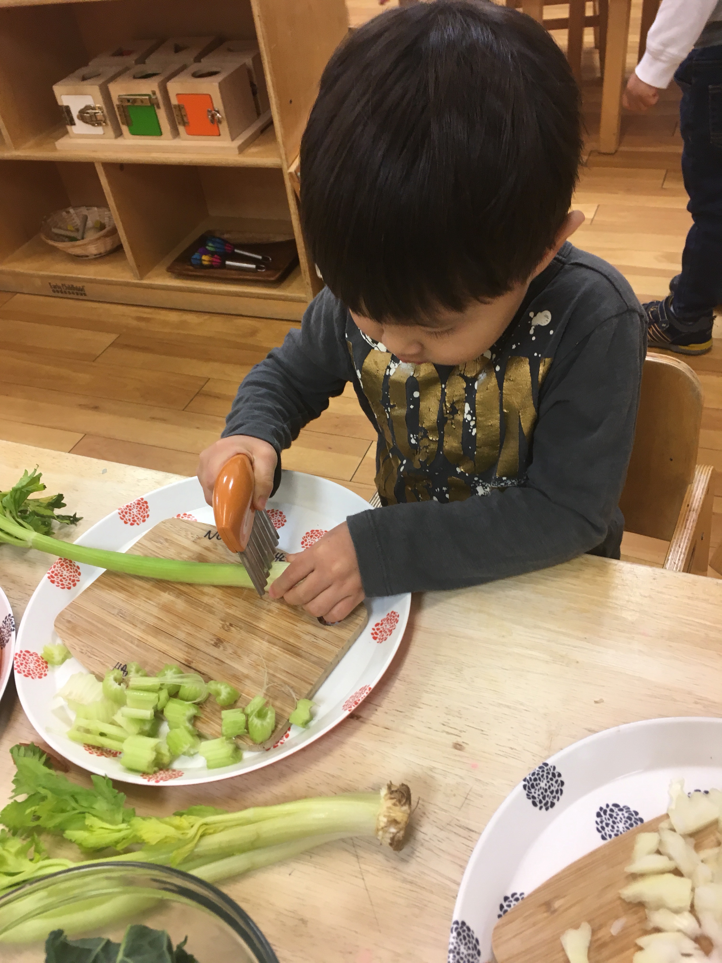 Child cutting celery in a Montessori school