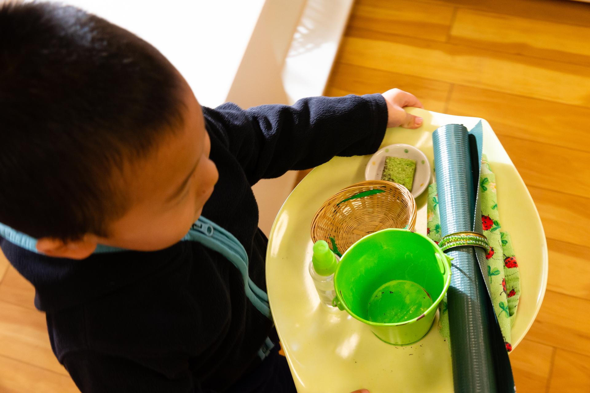Boy carrying his plate sitting in a Montessori classroom