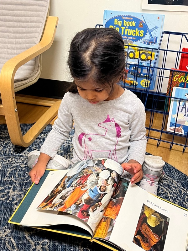 Preschooler learning how to read a book at Lifetime Montessori school in San Diego