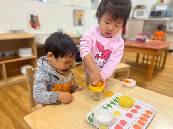 Toddlers Juicing an Orange together at Lifetime Montessori School San Diego 