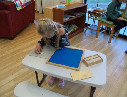 Montessori Elementary girl learning complex problems in an easy way