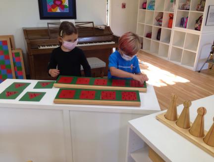 Two Elementary Montessori children working together in-person learning