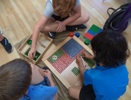 Elementary children solving math problems in a Montessori classroom