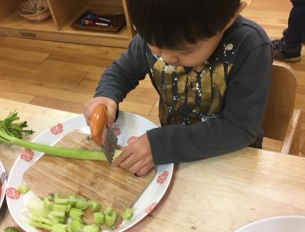 Child cutting celery in a Montessori school