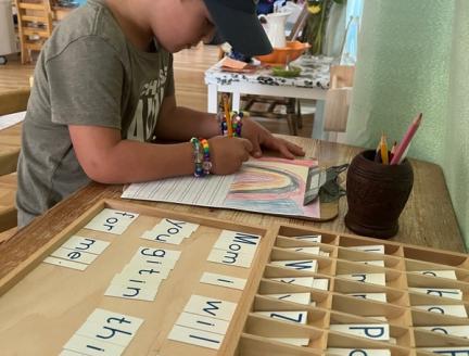 Child using his imagination and learning how to write in a Montessori classroom in San Diego