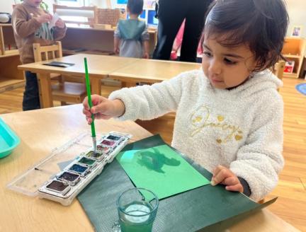Toddler painting in a Montessori classroom at Lifetime Montessori School