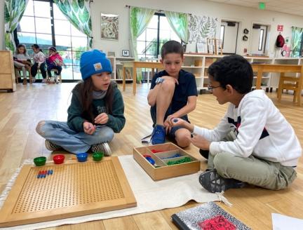 Elementary Montessori Students working together to solve problems without technology