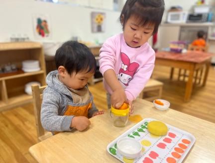 Toddlers Juicing an Orange together at Lifetime Montessori School San Diego 