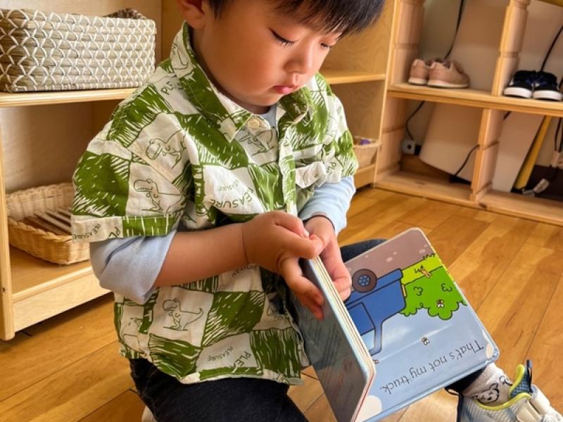 reading a book during potty training at Lifetime Montessori School in Santaluz