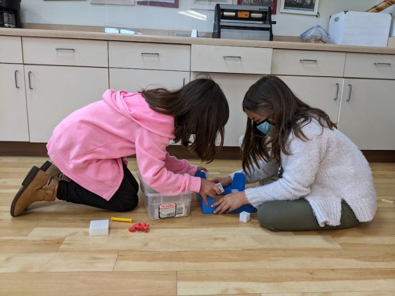 Two Elementary Montessori children working together in-person learning