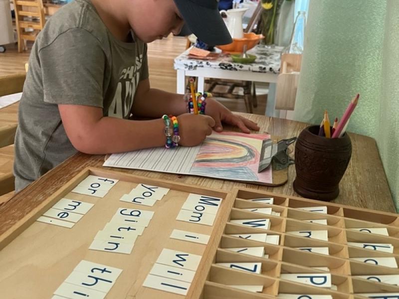 Child using his imagination and learning how to write in a Montessori classroom in San Diego