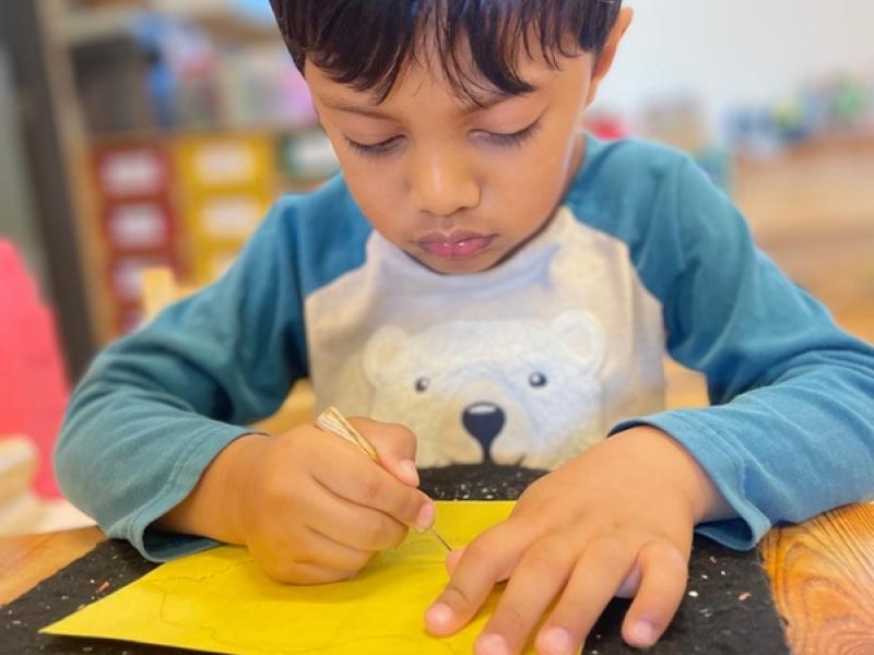 A Primary child concentrating and being observed in his Montessori Classroom in San Diego