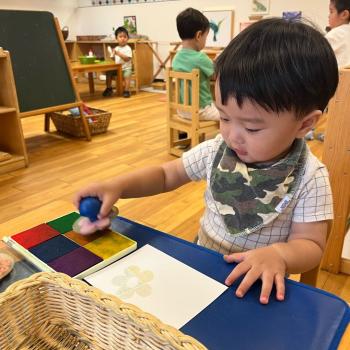 Toddler stamping paper at Lifetime Montessori School