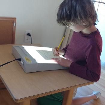 Elementary Child reading with light therapy