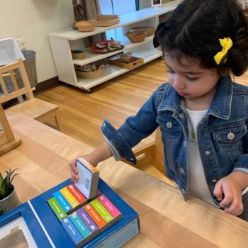 Toddler independently reading books at Lifetime Montessori School 