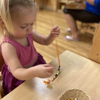 Toddler independently sewing at Lifetime Montessori School 