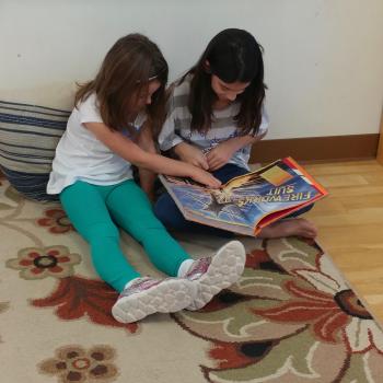 Two Elementary girls reading a book