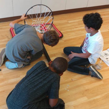 Elementary children installing basketball hoop at Lifetime Montessori school Engineering