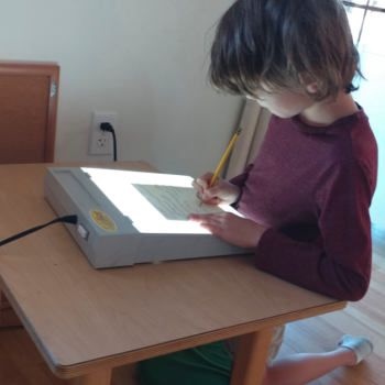 Elementary Child reading with light therapy