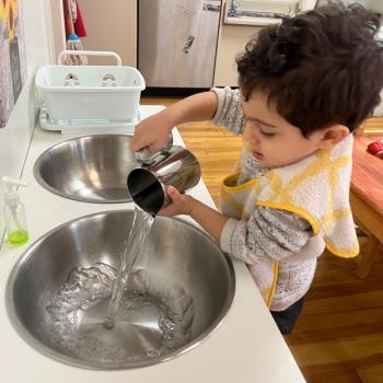 Toddler independently pouring water at Lifetime Montessori School 